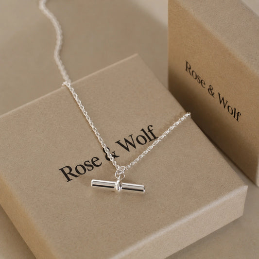Sterling silver T-bar necklace displayed on Rose & Wolf jewellery packaging.