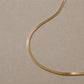 14ct gold vermeil snake chain necklace displayed on a neutral stone background.