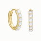 Pair of 14ct gold vermeil huggie hoop earrings featuring six faceted rainbow moonstones in a claw setting. One earring is shown angled to display the 925 hallmark, with the other shown from the front on a white background.